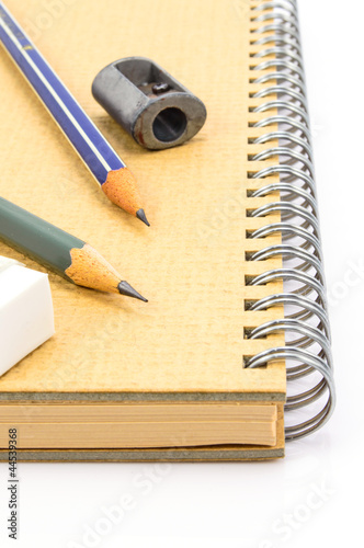 Two Wooden pencil, eraser and sharpener on recycle notebook on w