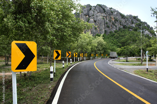 Curve road sign on down hill