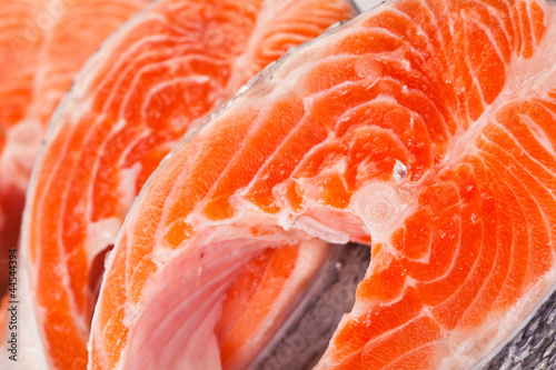 Raw salmon steaks are zoomed on white