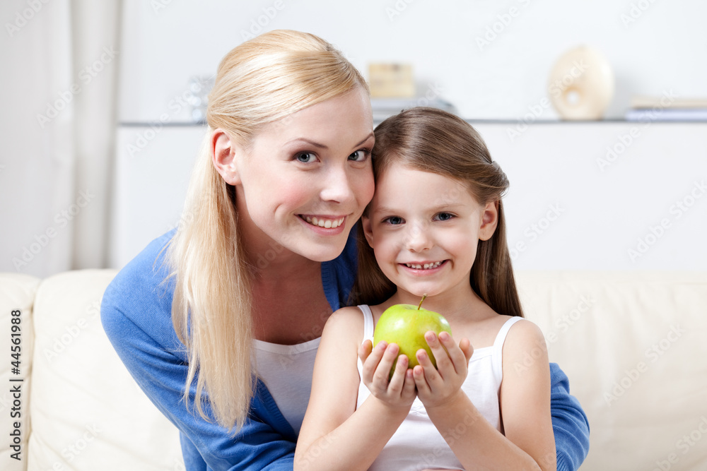Smiley mummy with her keeping sweet green apple daughter Smiley mummy with her keeping sweet green apple daughter