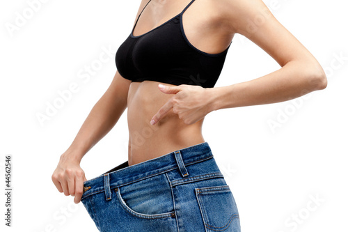 Body of a slim girl wearing big jeans, isolated on white