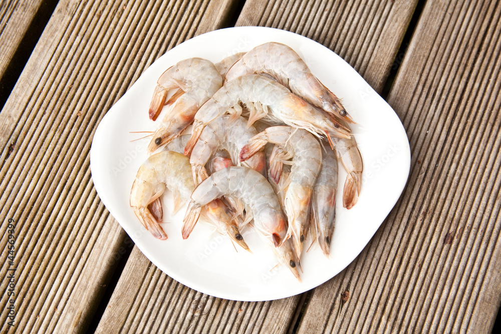 Uncooked tiger prawns on a white plate. Uncooked tiger prawns on a white plate.