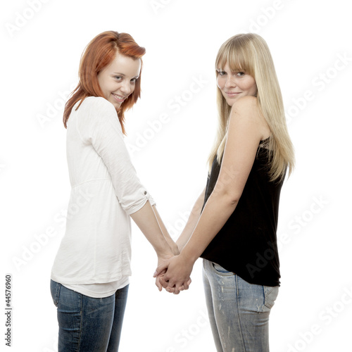 young beautiful red and blond haired girls holding hands