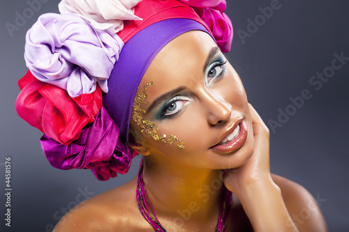 Beautiful fashion model - colorful headwear smiling, gold makeup