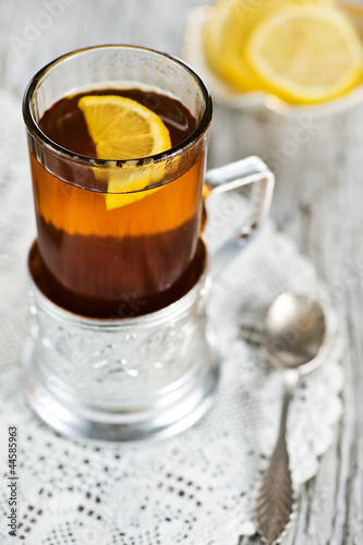 Tea and lemon in the glass with holder