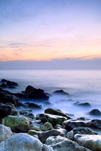 Seashore with misty water at sunset © Aleksey Sagitov