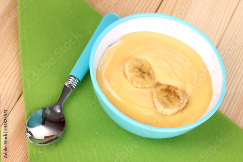 Yogurt with banana on wooden table photo