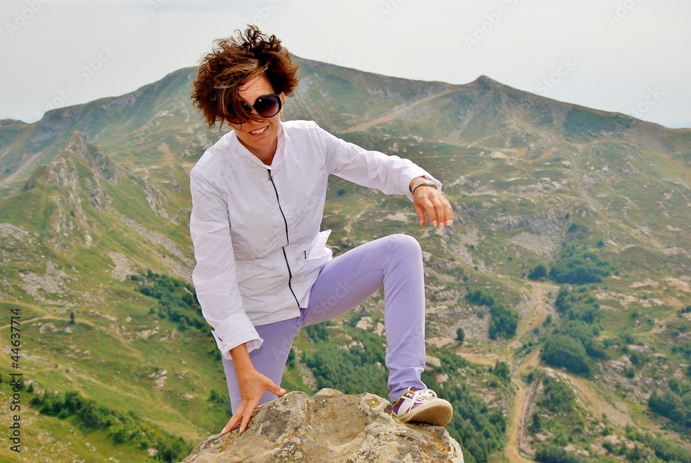 Naklejka premium donna a piedi in cima alla montagna