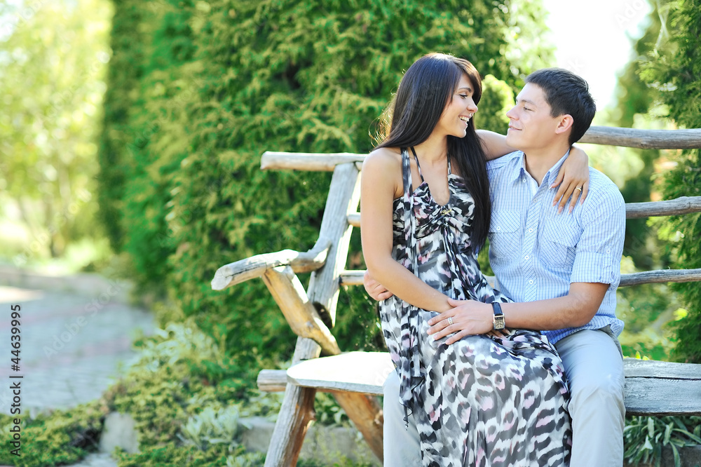 Naklejka premium Portrait of happy young couple smiling while sitting together
