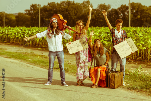 Fototapeta Hippie Group Hitchhiking on a Countryside Road