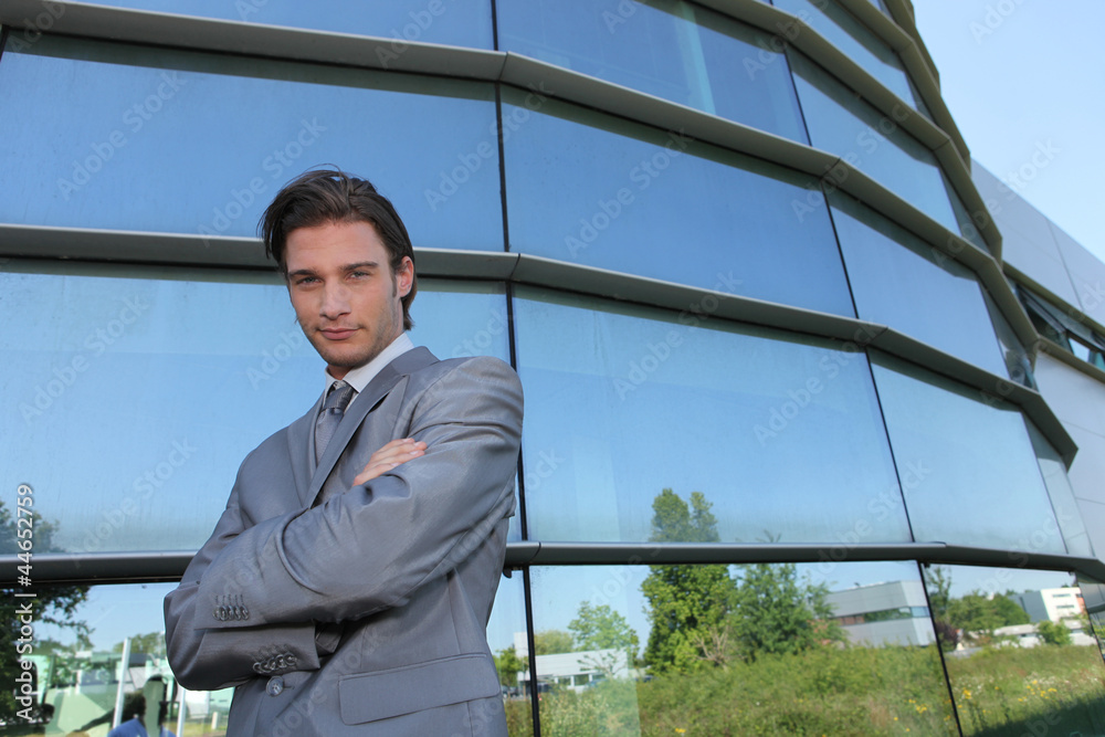 Young businessman standing in front of a building Young businessman standing in front of a building
