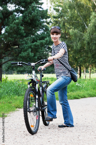 Девушка с велосипедом в парке