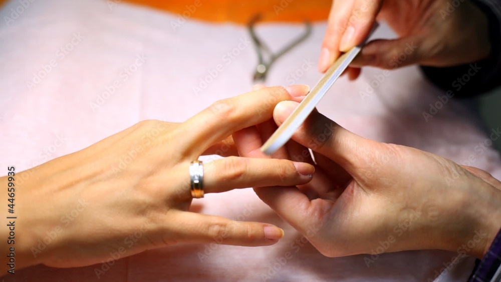 Cosmetician does manicure and saws nails of client Cosmetician does manicure and saws nails of client