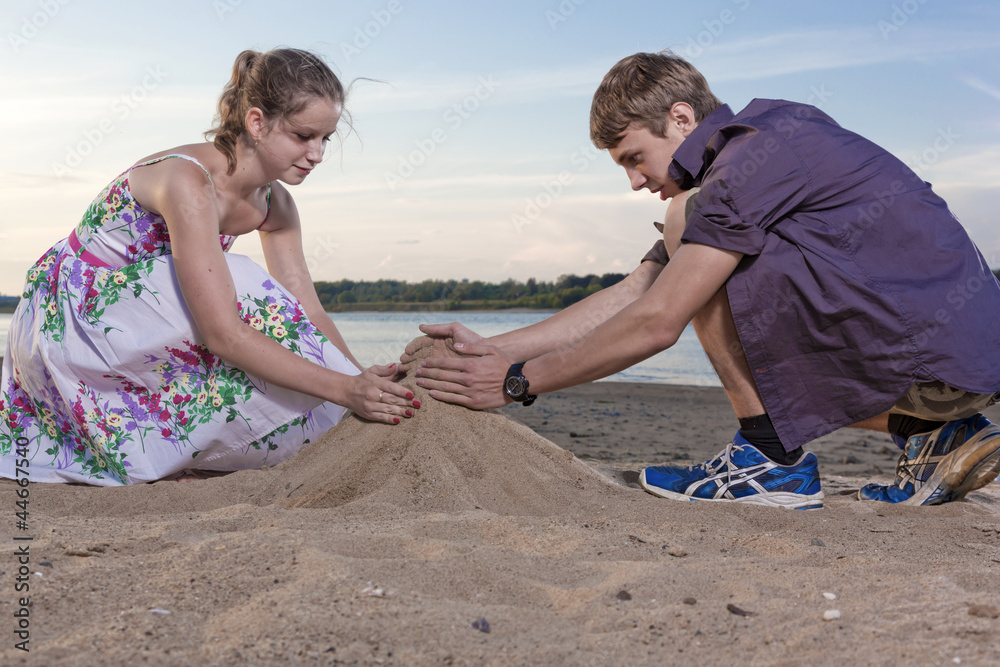 The guy and the girl fill a heap of sand The guy and the girl fill a heap of sand