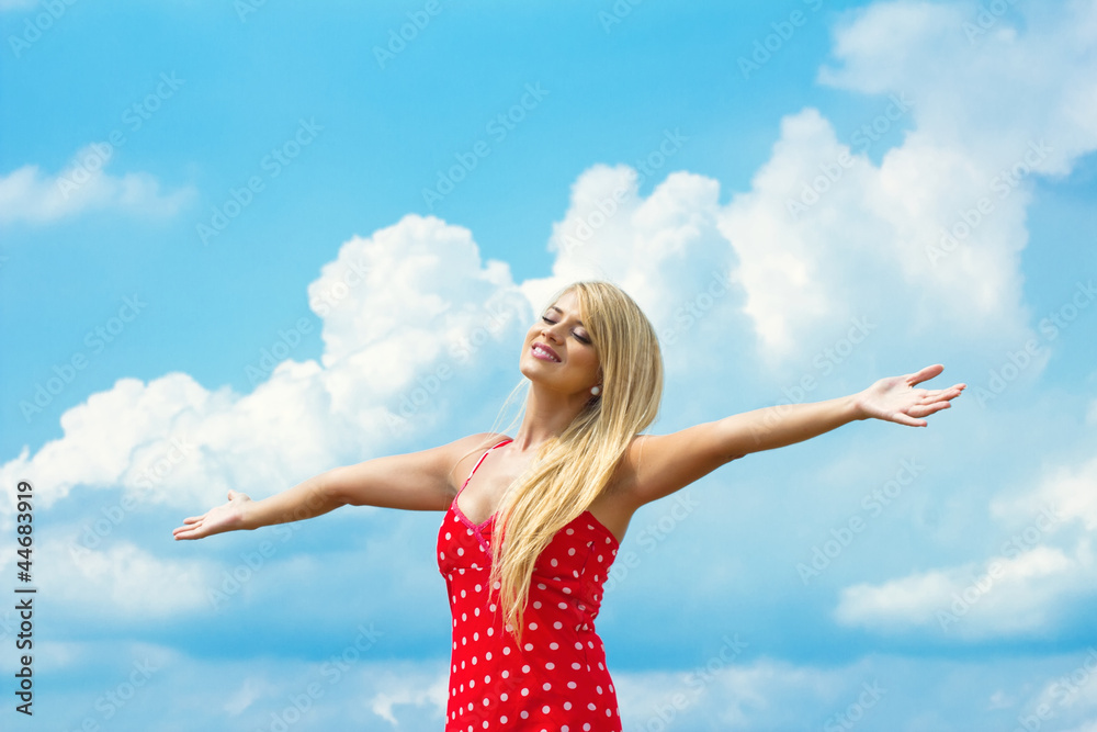 Pretty young woman with arms raised against blue sky-closed eyes Pretty young woman with arms raised against blue sky-closed eyes