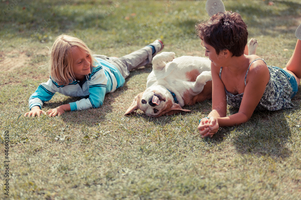 Fototapeta premium Two Children Playing with the Dog