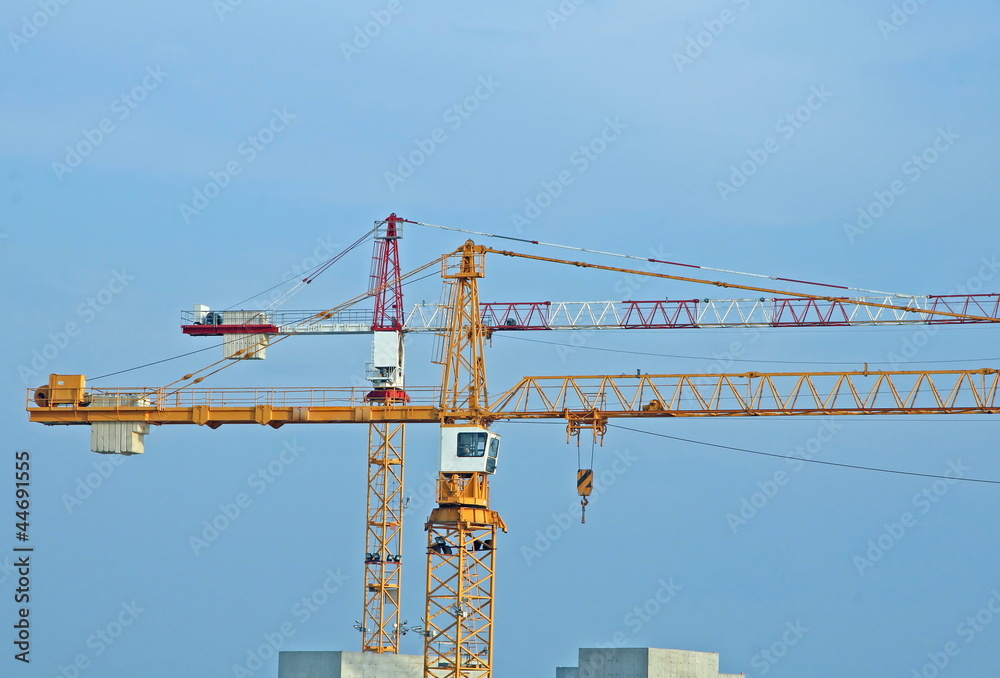 two tall steel crane at a construction site of construction
