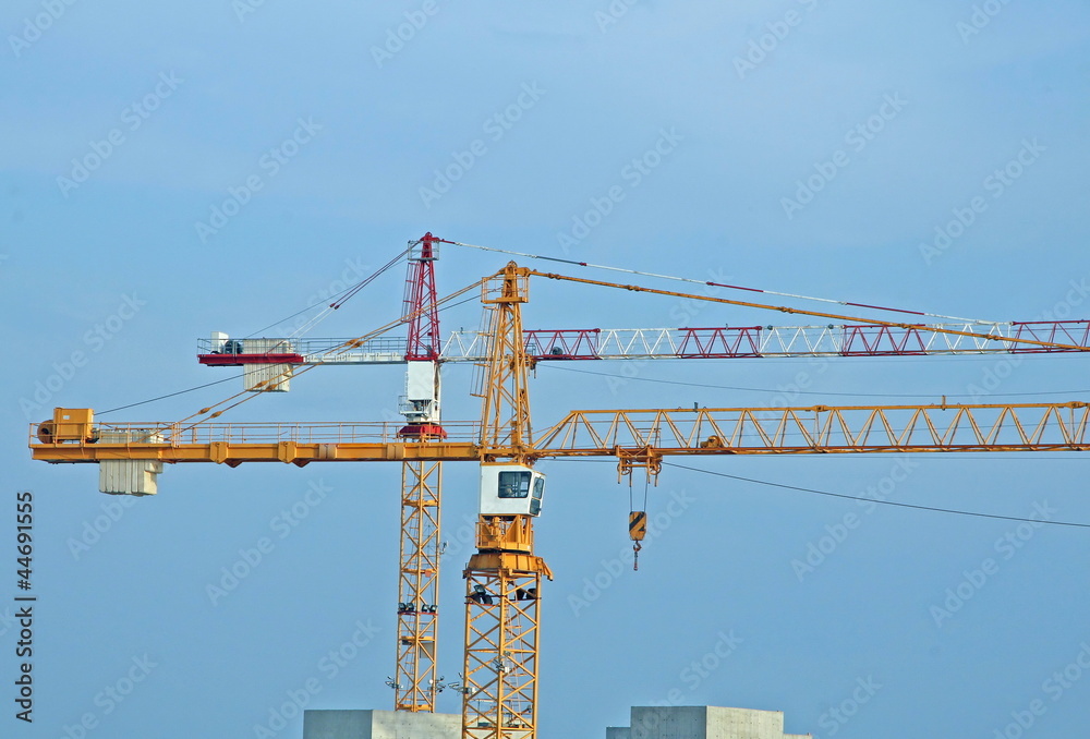 two tall steel crane at a construction site of construction two tall steel crane at a construction site of construction