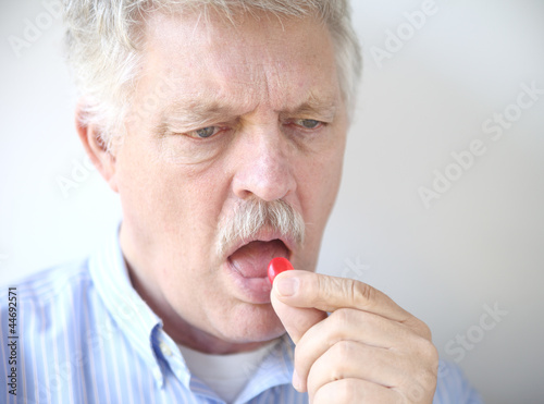 senior man with cough drop photo