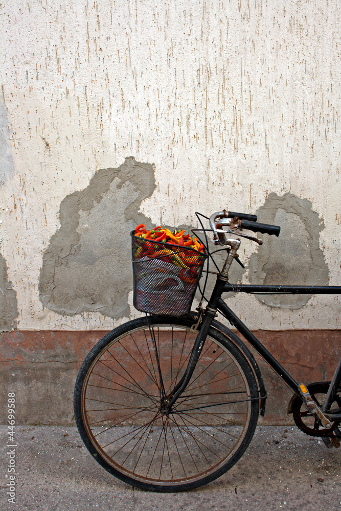Naklejka premium Old rusty bicycle with colorful peppers in basket