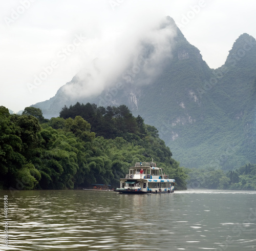 People are boating on the mountain river near Yangshuo