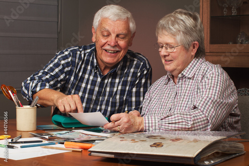 Happy senior couple making a scrapbook