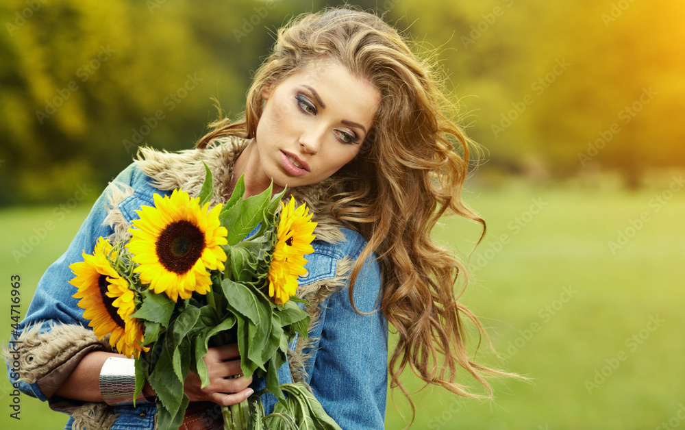 Young fashion woman with a bouquet of sunflowers in the field Young fashion woman with a bouquet of sunflowers in the field