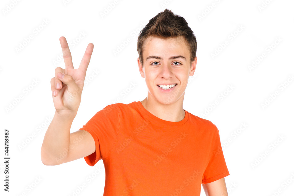 smiling teen boy shows victory sign isolated over white smiling teen boy shows victory sign isolated over white