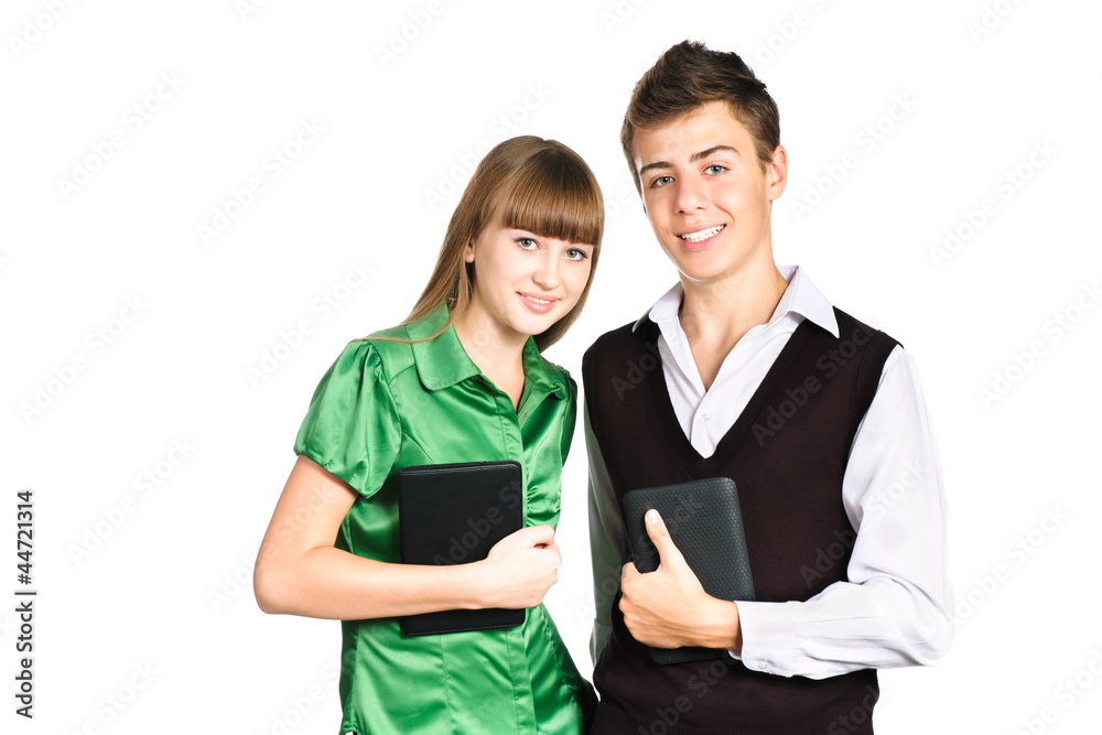 Two students holding pc tablets standing isolated on white backg Two students holding pc tablets standing isolated on white backg