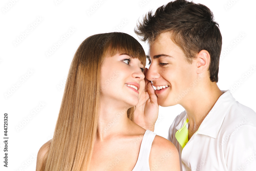 Closeup portrait of a handsome boy whispering in his girlfriend Closeup portrait of a handsome boy whispering in his girlfriend
