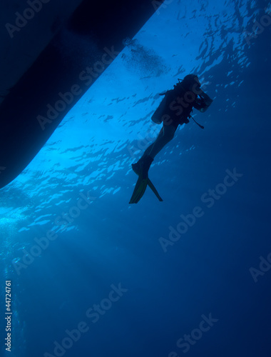 Silhouette of diver with sun disk behind
