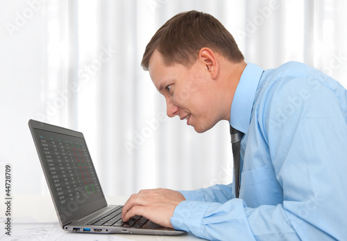 portrait of young business man working with laptop at his desk © spaxiax