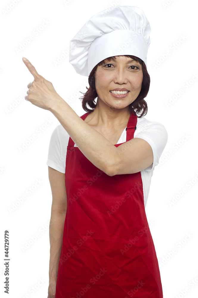 Female chef in uniform pointing away. Copy space concept Female chef in uniform pointing away. Copy space concept