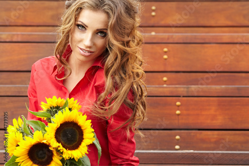 Leinwand Poster Fashion woman with sunflower at outdoor.