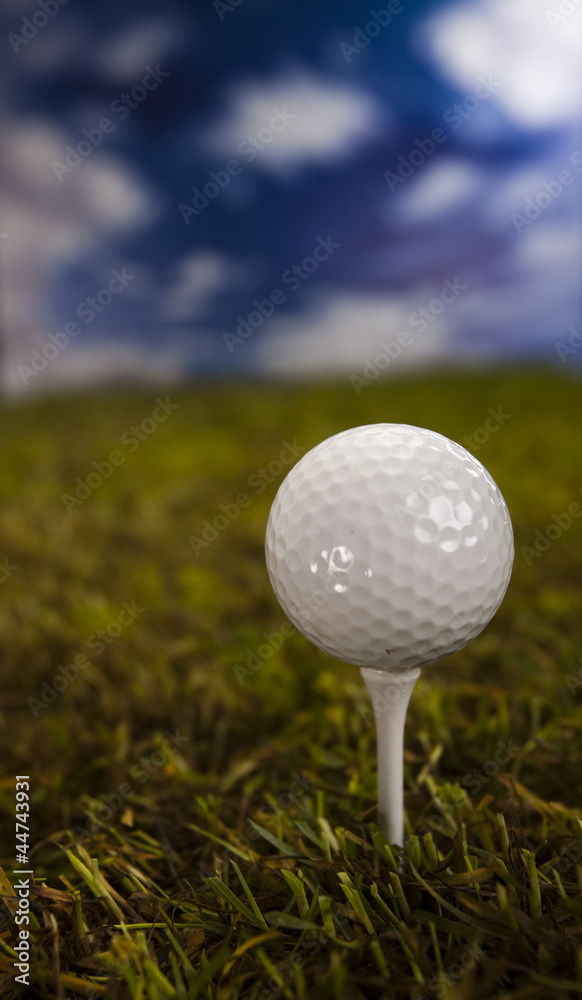 Golf ball on green grass over a blue sky Golf ball on green grass over a blue sky