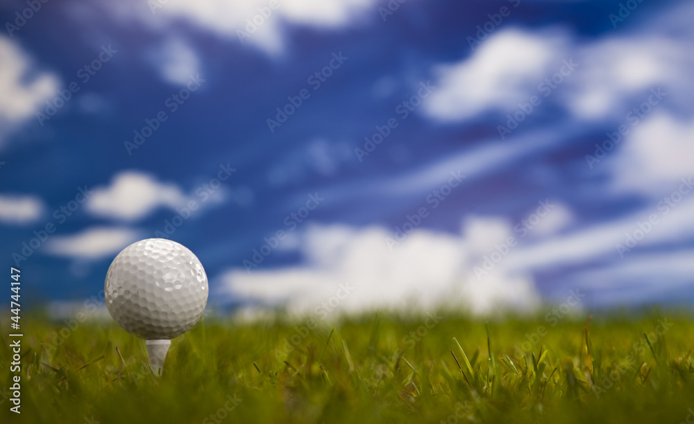 Golf ball on green grass over a blue sky Golf ball on green grass over a blue sky