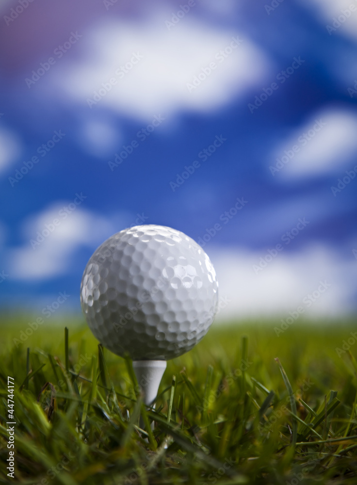 Golf ball on green grass over a blue sky Golf ball on green grass over a blue sky