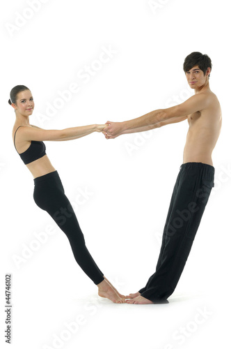 Couple gymnasts practicing a complex double yoga pose.