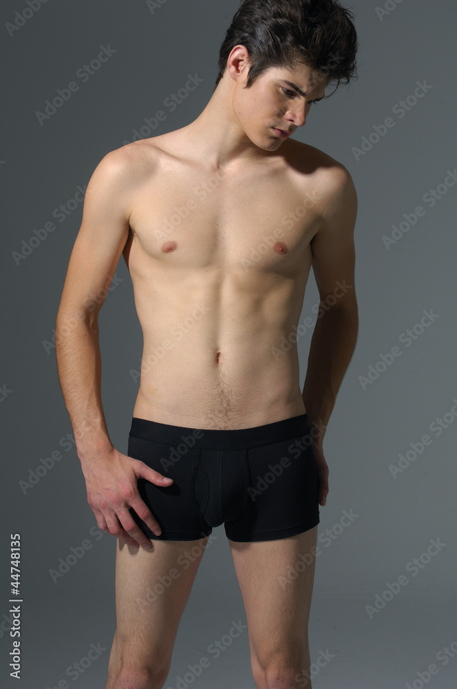 sexy handsome muscular young man on gray background