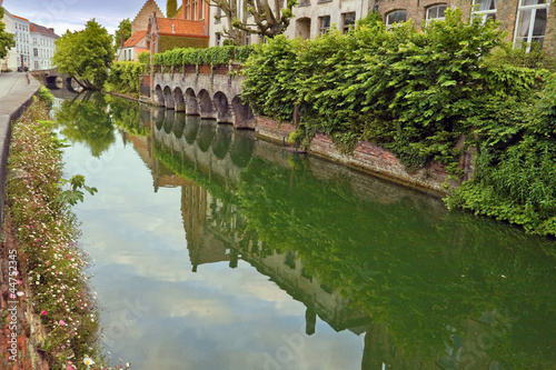 Green view of the canal of old part in Bruges. © petunyia