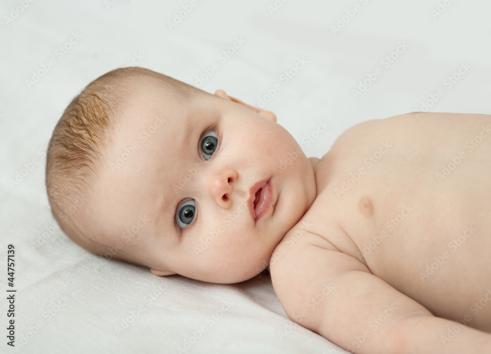 Baby girl lying on back looking at camera Baby girl lying on back looking at camera
