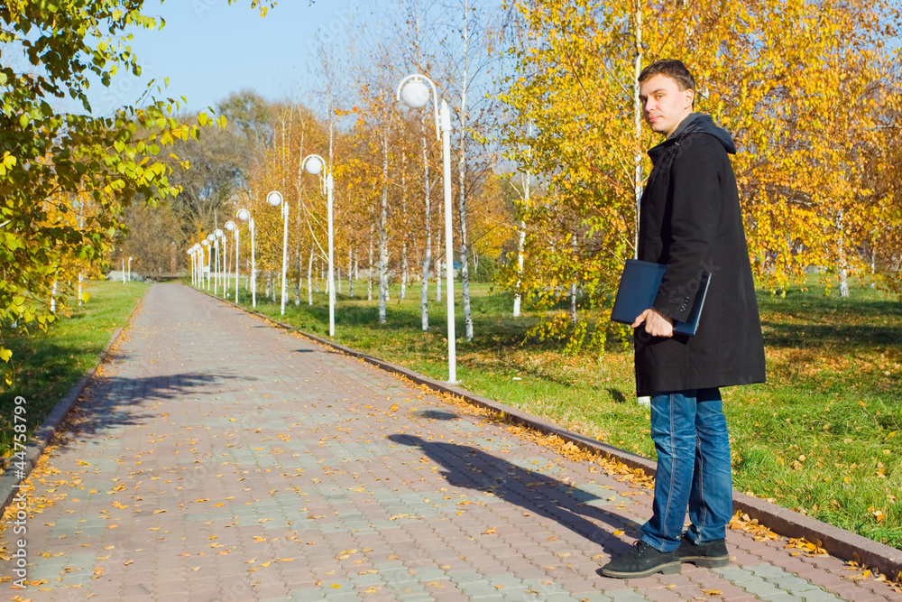 © petunyia - Businessman holding laptop in the park