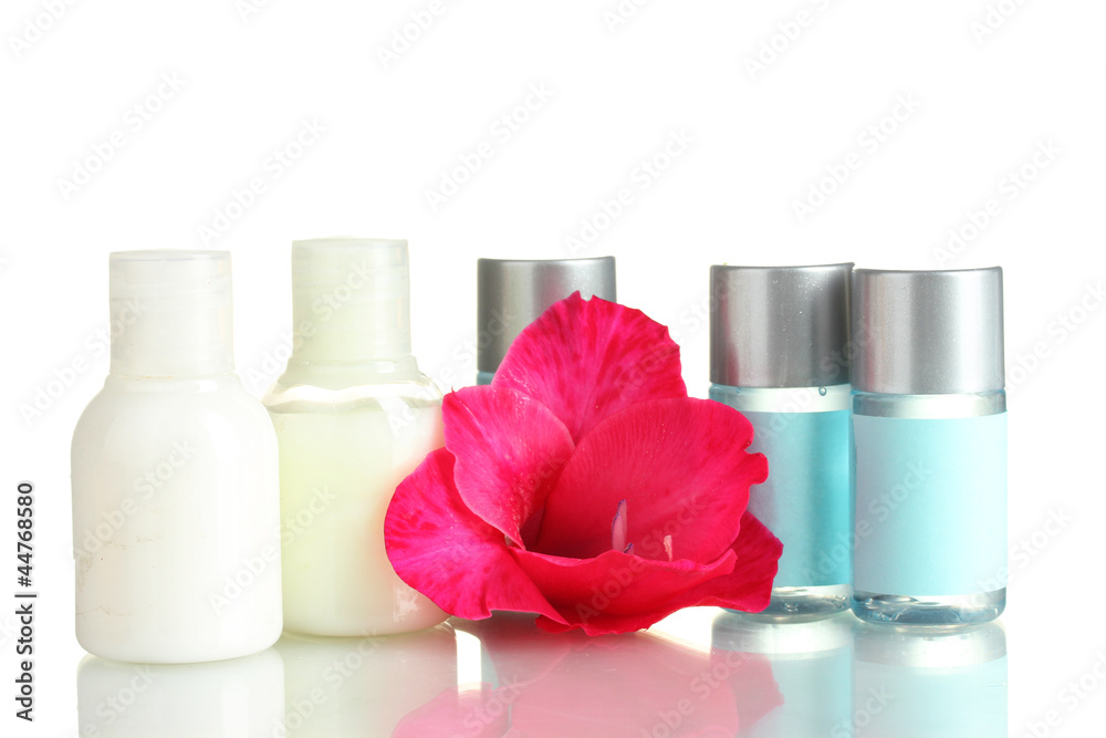 cosmetic bottles and flower, isolated on white.