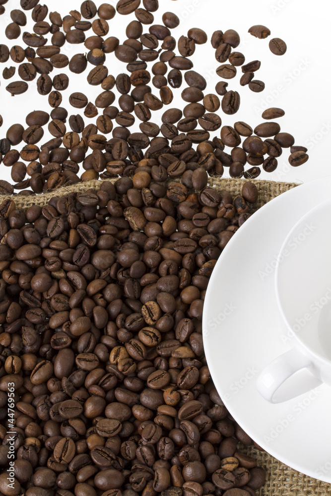 Obraz premium kaffebohnen auf einem leinensack mit kaffeetasse hochformat