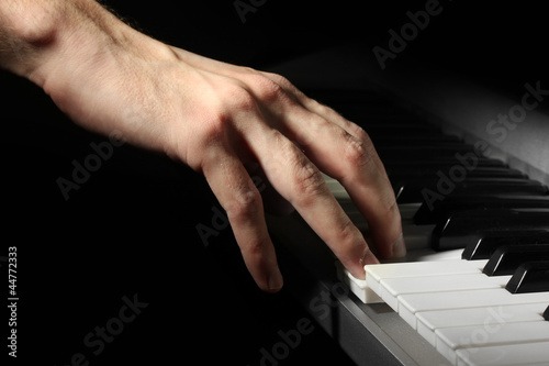 hand of man playing piano © Africa Studio