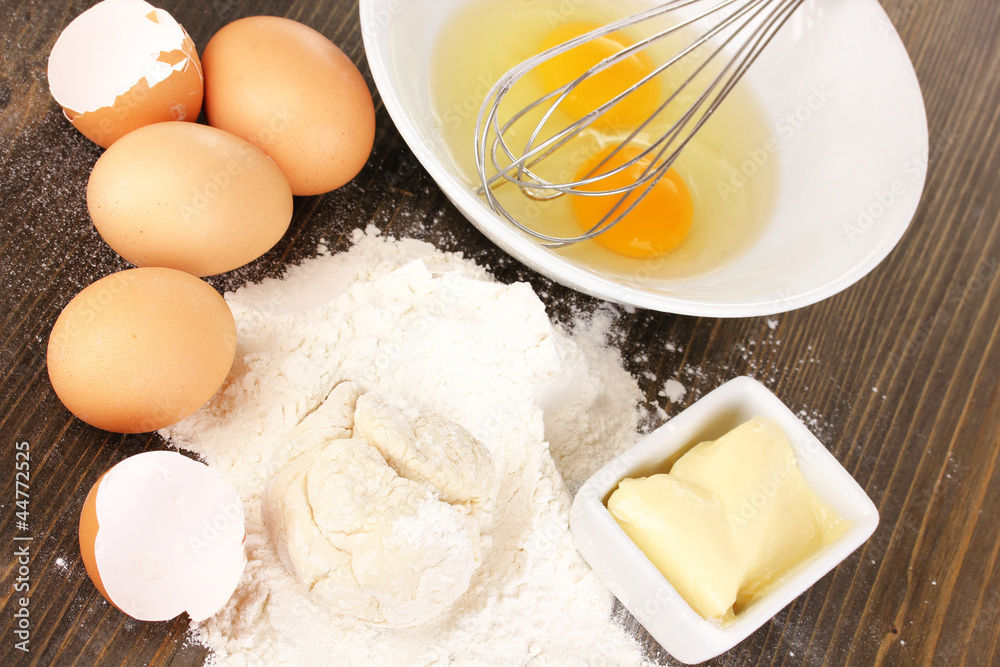 Eggs, flour and butter close-up on wooden table Eggs, flour and butter close-up on wooden table