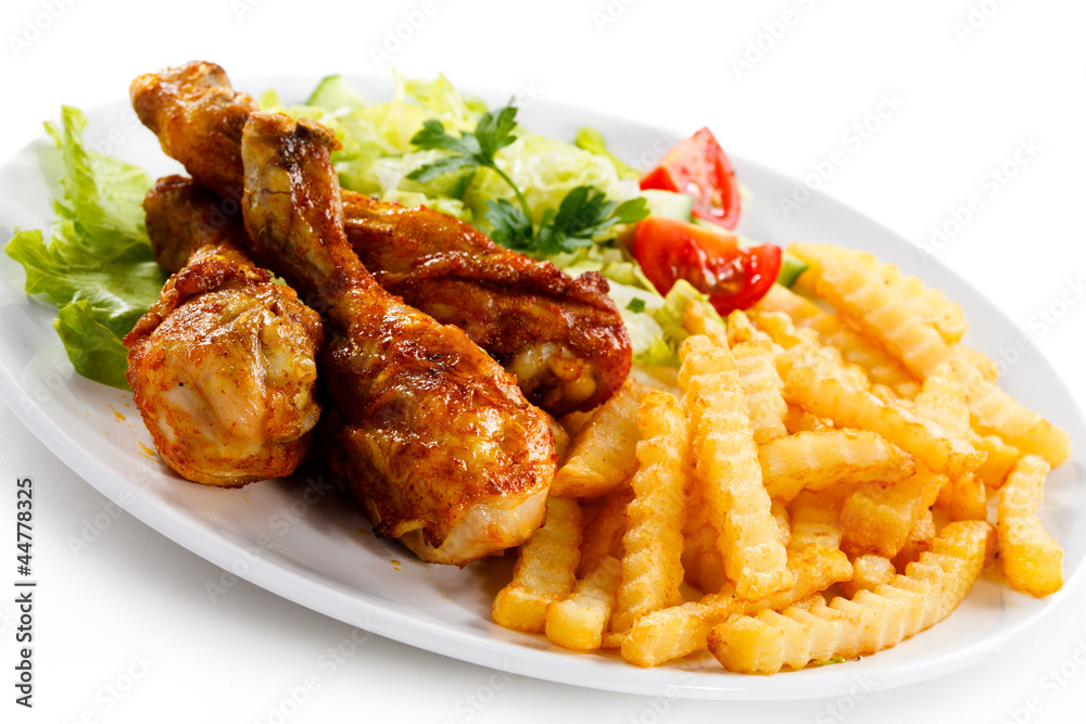 Grilled chicken legs with chips and vegetables