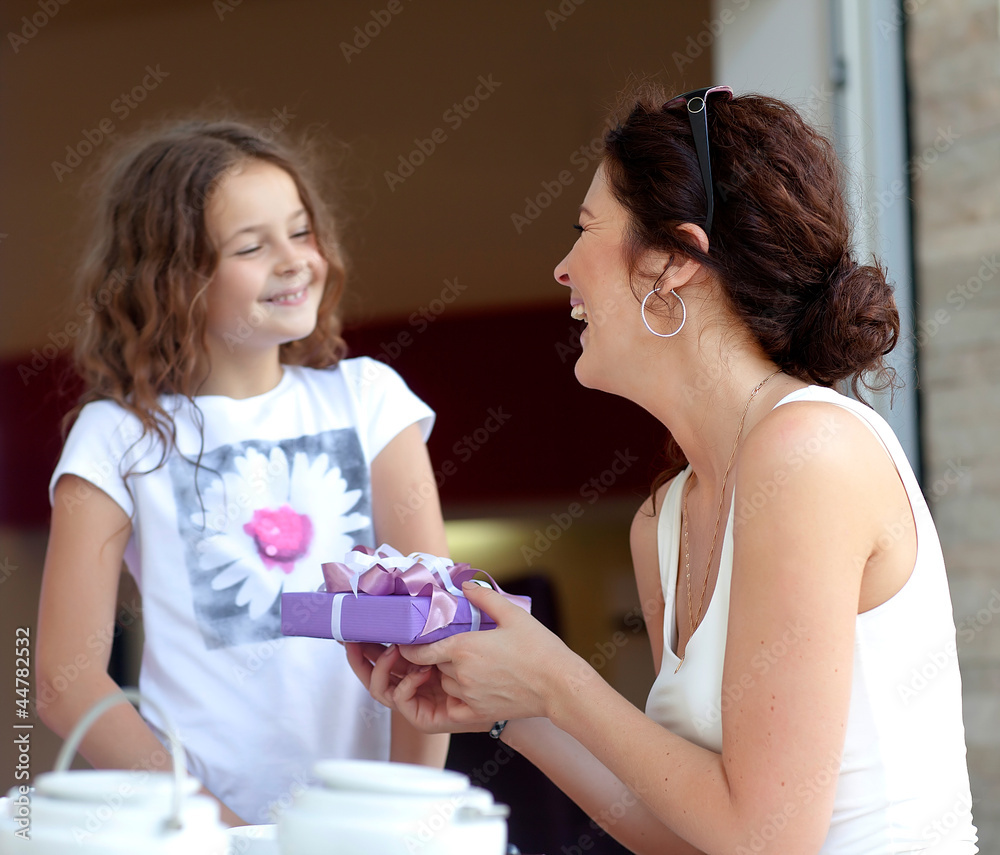 Little beautiful pretty girl giving a gift to her happy mother - Little beautiful pretty girl giving a gift to her happy mother -