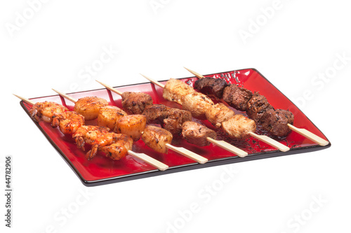 Delicious satay collection on a red plate