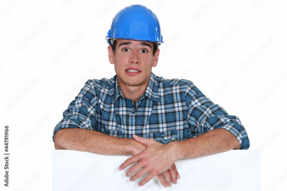 Anxious builder stood with blank board Anxious builder stood with blank board